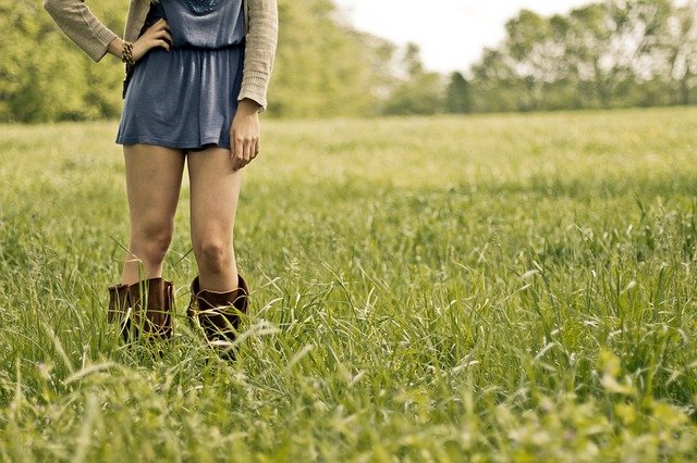 Žena s holými nohami stojaca vo vysokej tráve
